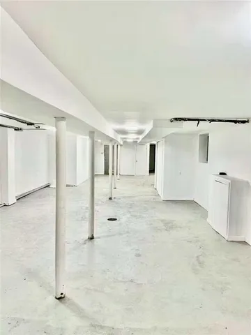 a view of a kitchen with kitchen island stainless steel appliances wooden floor and chandelier