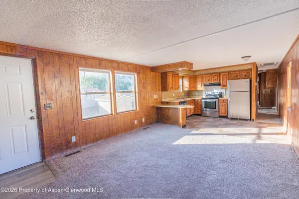 an empty room with a fireplace cabinet and windows