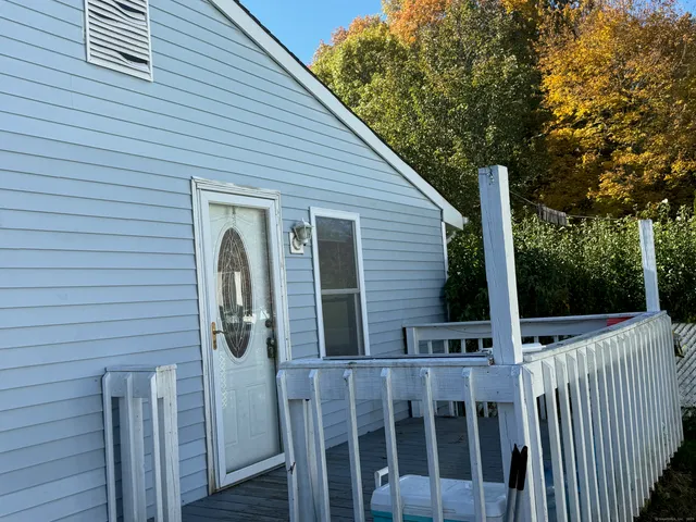 a view of a small house with wooden fence and trees