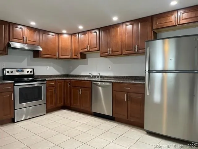 a kitchen with stainless steel appliances granite countertop a refrigerator sink and cabinets