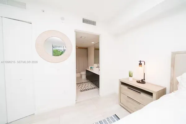a bedroom with a bed and a painting on the wall