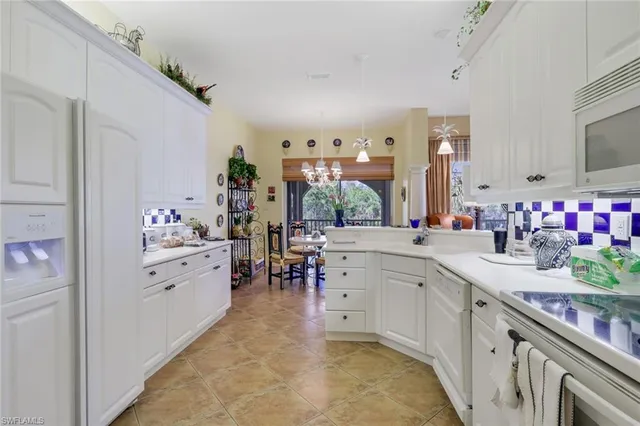 a large white kitchen with cabinets