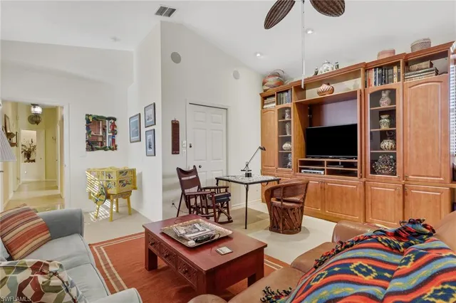 a living room with furniture a flat screen tv and a bookshelf
