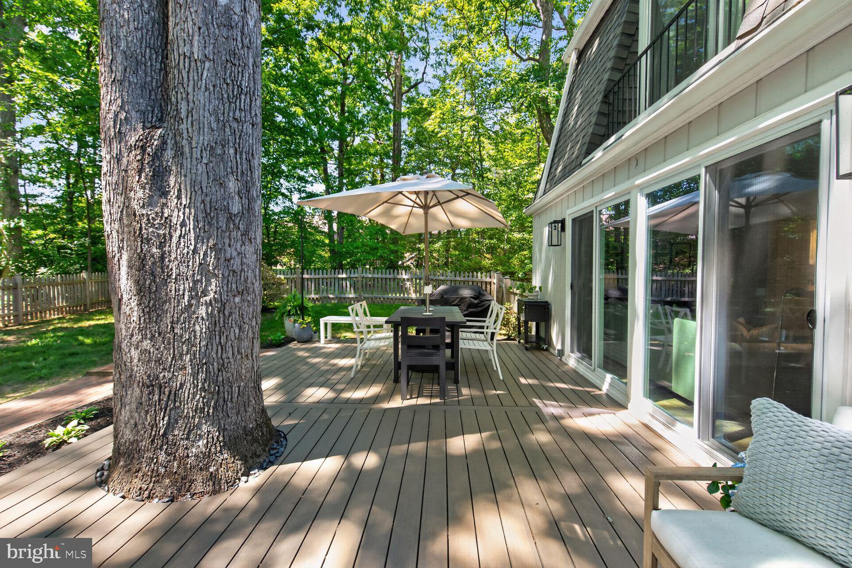 11201 Wedge Drive Reston, VA 20190 - Photo 26 of 31 a view of a patio with table and chairs under an umbrella with large trees