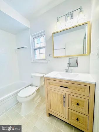 a bathroom with a granite countertop toilet sink and a mirror