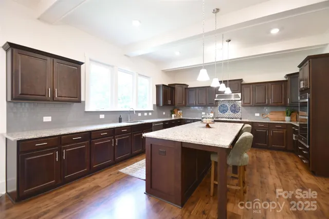 a kitchen with kitchen island granite countertop wooden cabinets and white appliances