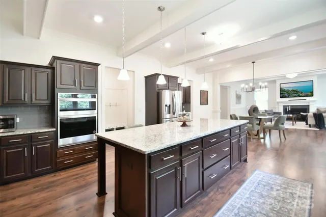 a large kitchen with lots of counter space a sink appliances and cabinets