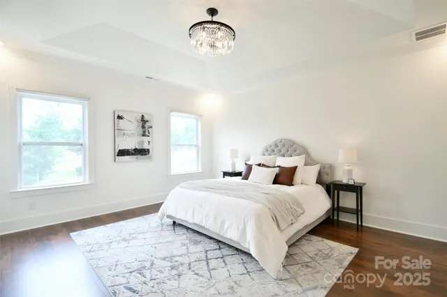 a bedroom with a bed window and wooden floor