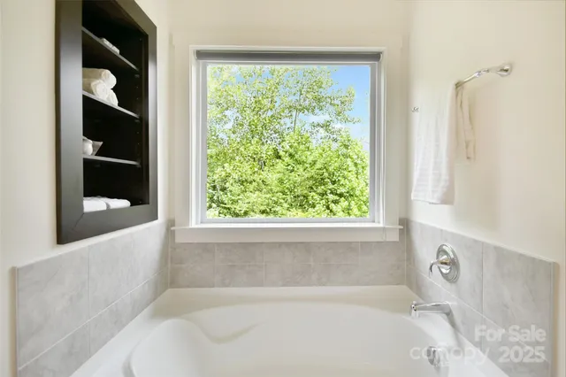 a white bath tub sitting in a bathroom next to a window