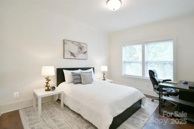 a bedroom with a bed and a table in it with a window