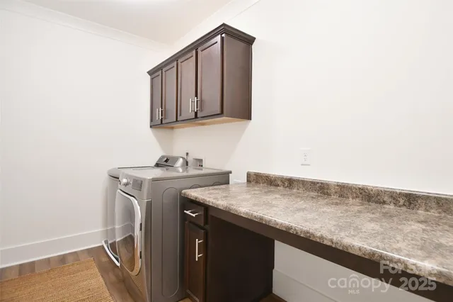 a utility room with granite countertop cabinets washer and dryer