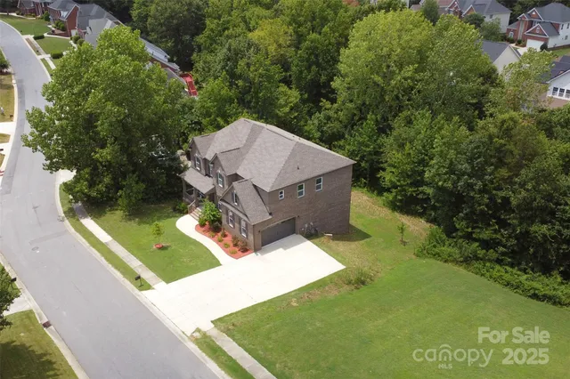 a view of a small house with a yard and large trees