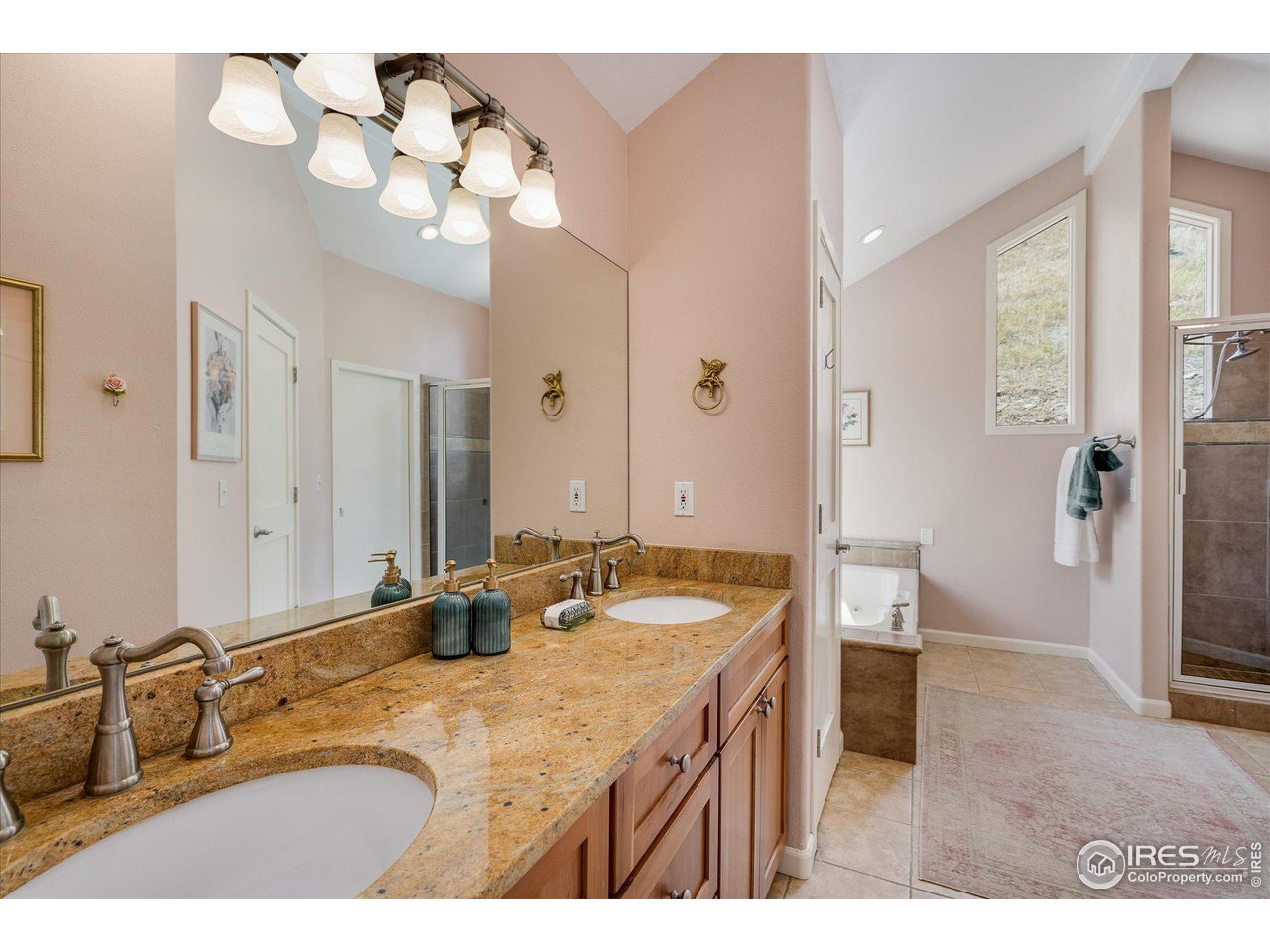 5251 Olde Stage Road Boulder, CO 80302 - Photo 20 of 39 a bathroom with a granite countertop sink a large mirror and a shower