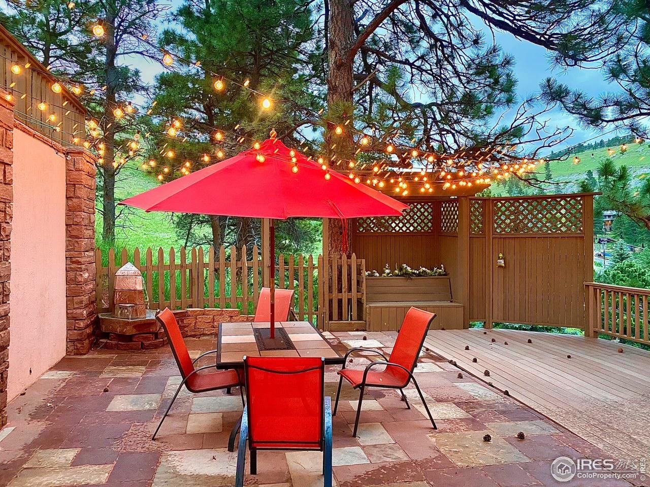 5251 Olde Stage Road Boulder, CO 80302 - Photo 28 of 39 a patio with tables and chairs under an umbrella