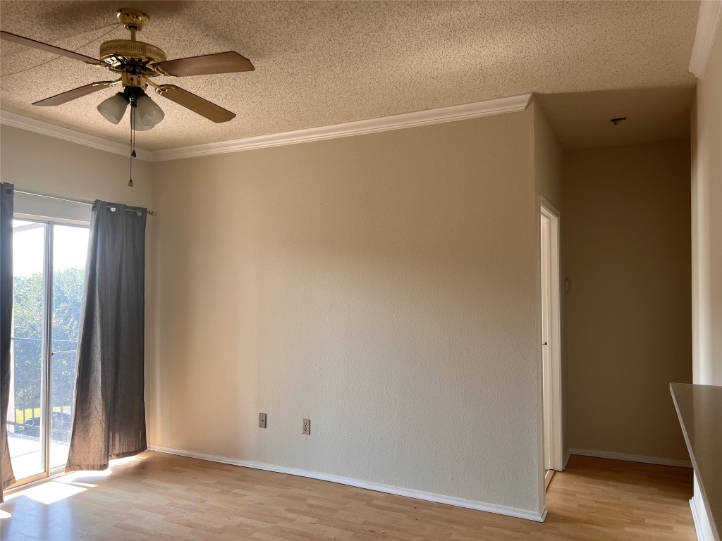 12166 Metric Boulevard, Unit 3007 Austin, TX 78758 - Photo 4 of 19 an empty room with wooden floor and fan