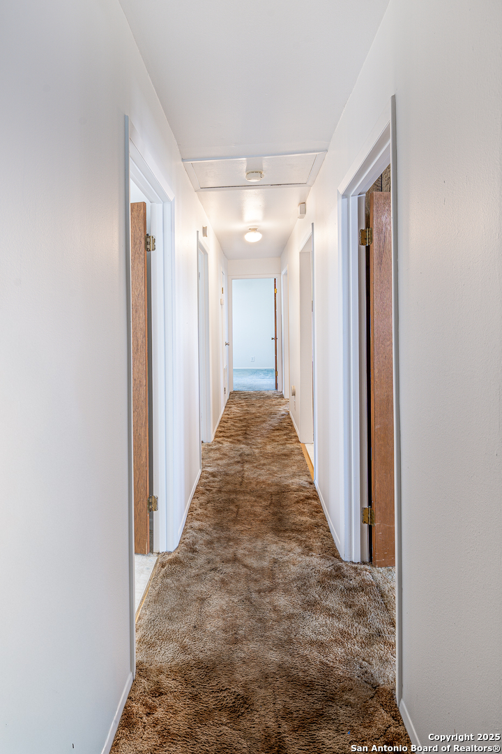 611 Austin Street Sabinal, TX 78881 - Photo 11 of 45 a view of a hallway with wooden walls