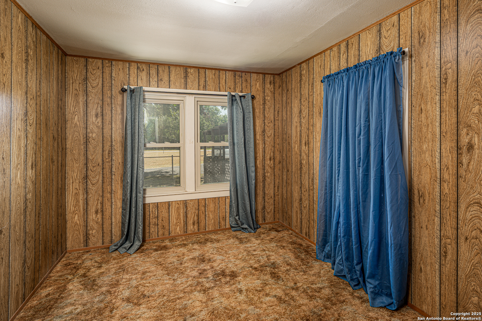 611 Austin Street Sabinal, TX 78881 - Photo 15 of 45 a view of an empty room with wooden walls