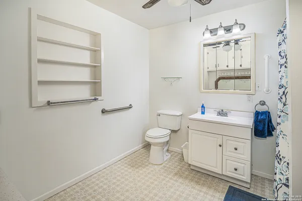 a bathroom with a toilet a sink a mirror and vanity