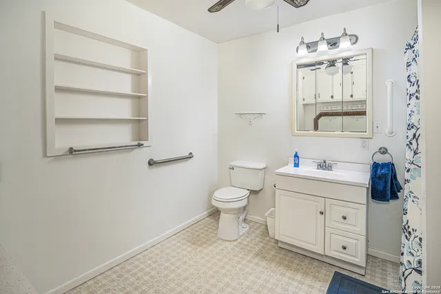 a bathroom with a toilet a sink a mirror and vanity