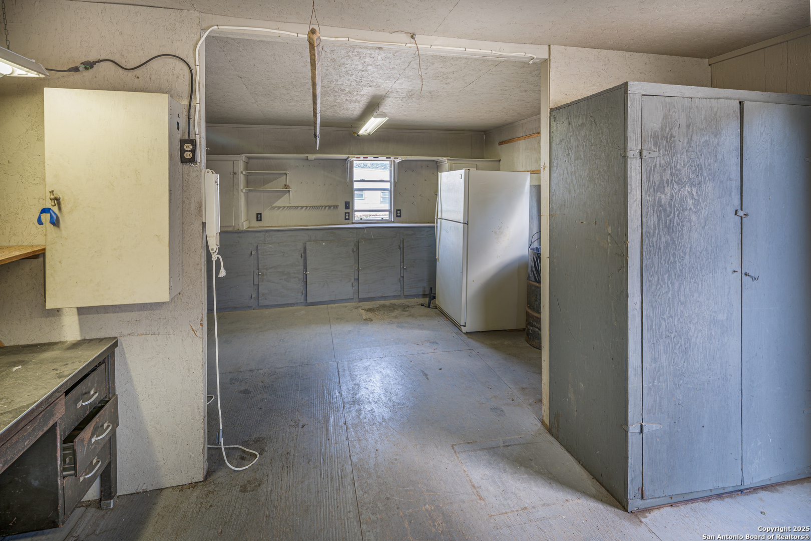 611 Austin Street Sabinal, TX 78881 - Photo 37 of 45 a view of a refrigerator in kitchen and an empty room