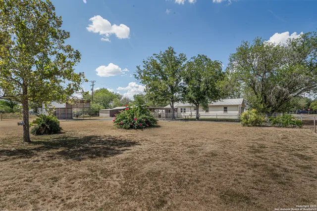 a view of house with yard and outdoor seating