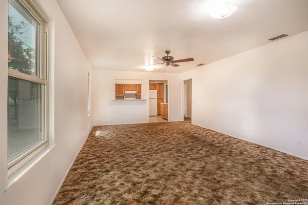 a view of a hallway with wooden floor and chandelier