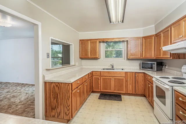 a kitchen with stainless steel appliances granite countertop a stove a sink and a microwave
