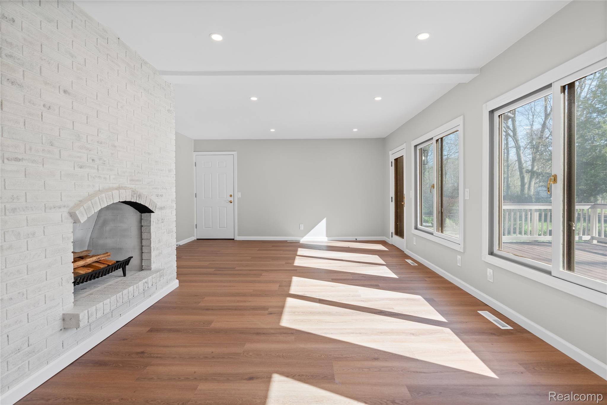 6273 Cold Spring Trail Grand Blanc, MI 48439 - Photo 21 of 48 Unfurnished family room featuring light wood-style floors, recessed lighting, a fireplace, and beamed ceiling