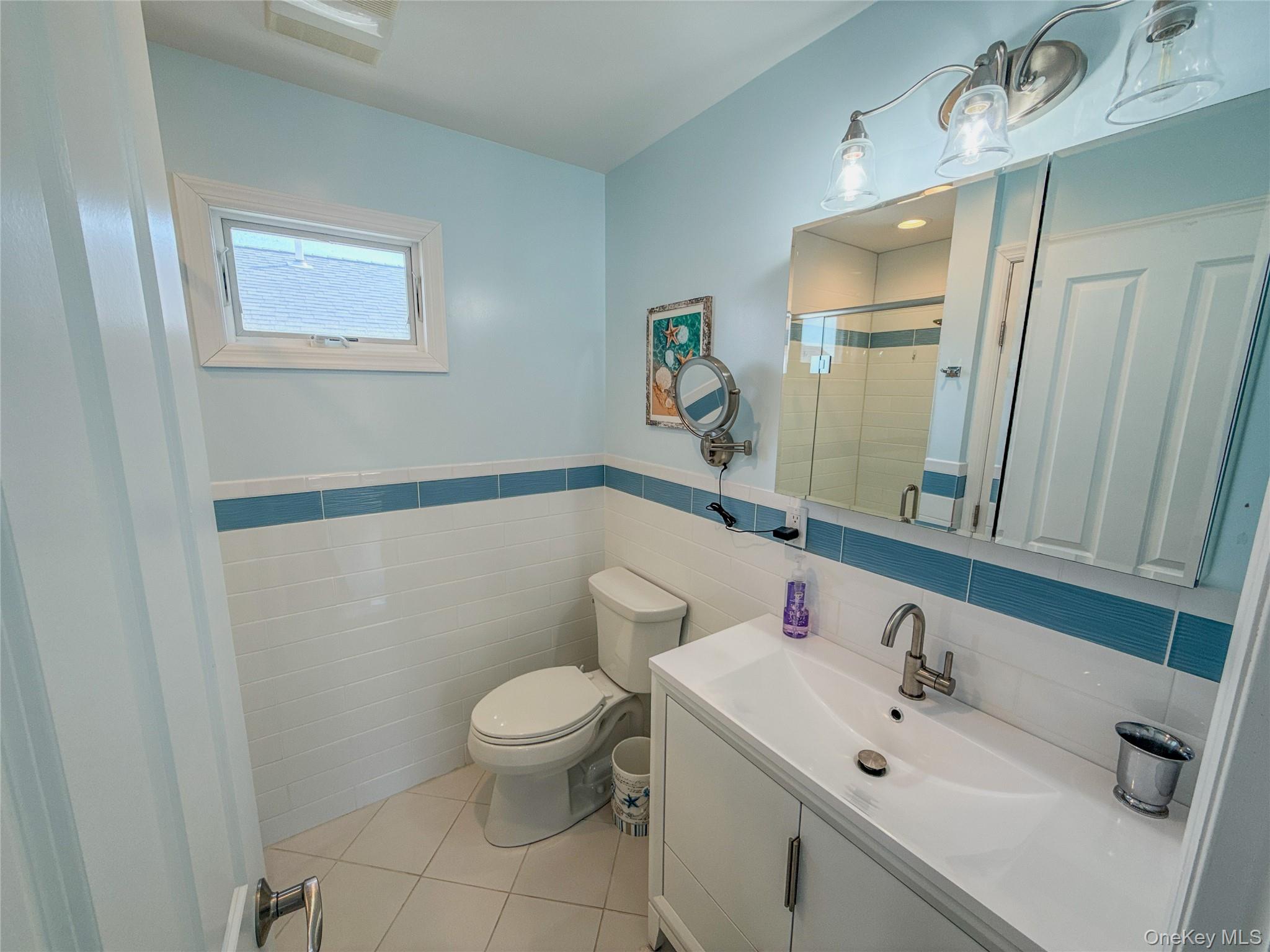 97 Cedarhurst Avenue Point Lookout, NY 11569 - Photo 12 of 21 a bathroom with a sink mirror and toilet