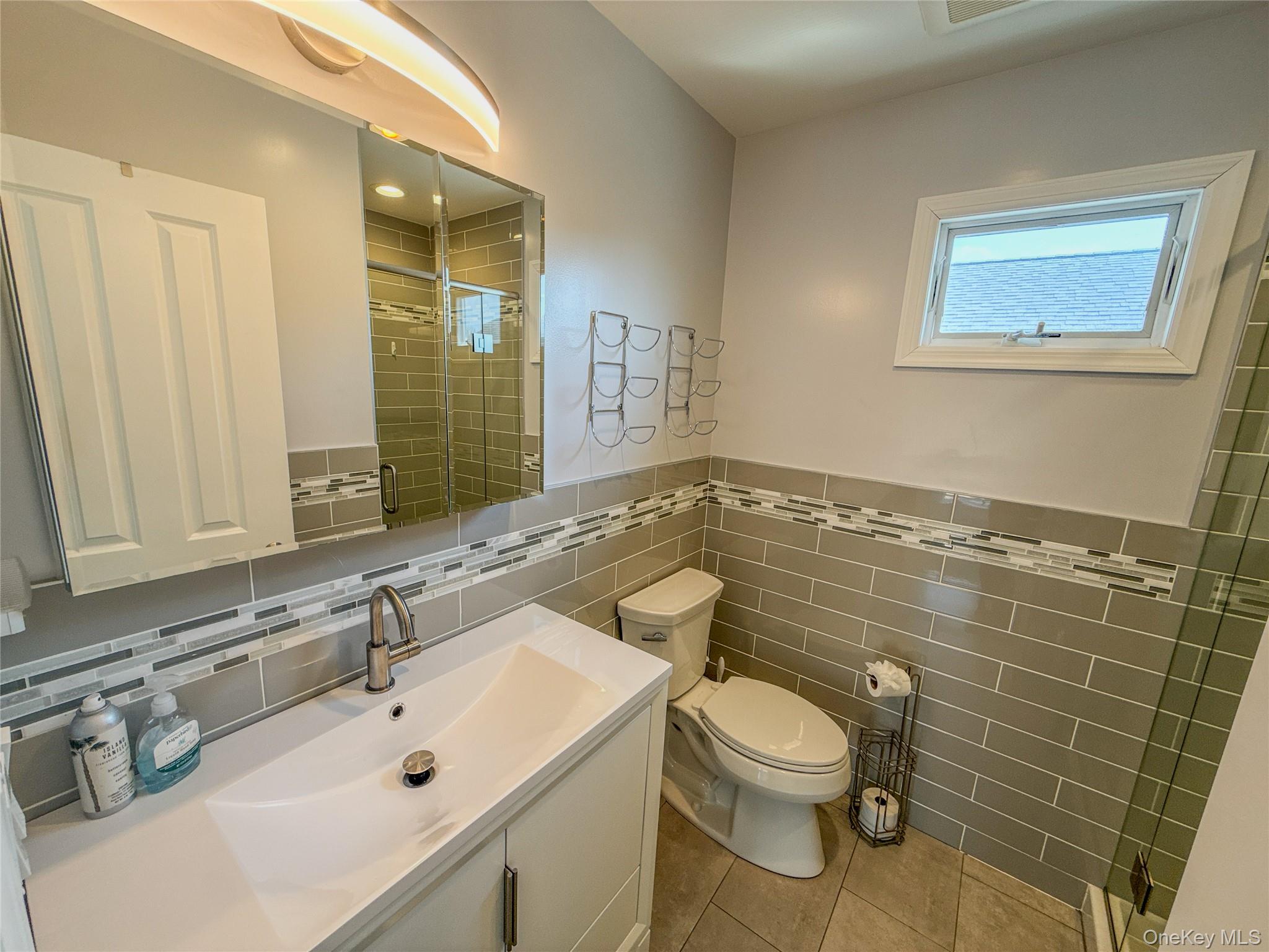 97 Cedarhurst Avenue Point Lookout, NY 11569 - Photo 16 of 21 a bathroom with a sink a toilet and a mirror