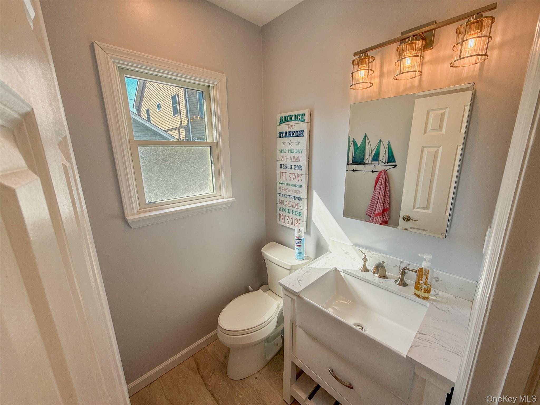 97 Cedarhurst Avenue Point Lookout, NY 11569 - Photo 9 of 21 a bathroom with a toilet a sink and a mirror