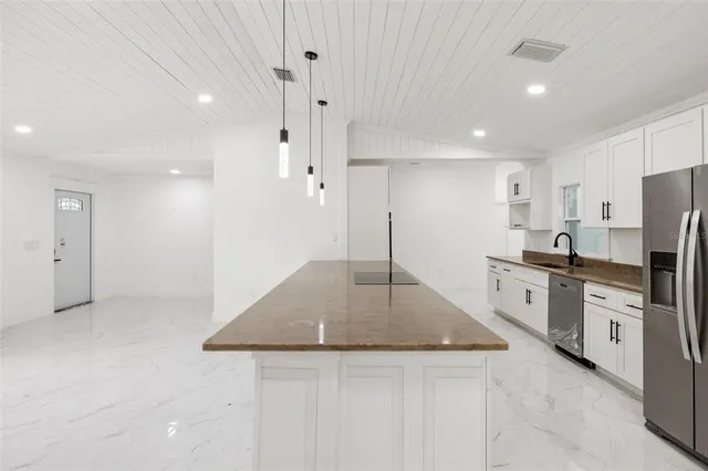 a kitchen with stainless steel appliances granite countertop a sink a stove and a refrigerator