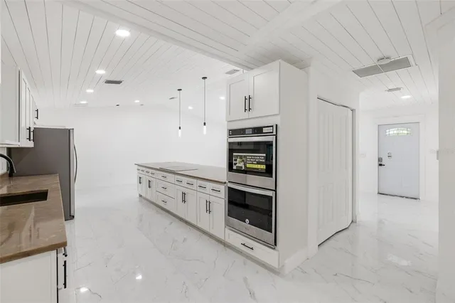 a kitchen with stainless steel appliances white cabinets and a refrigerator