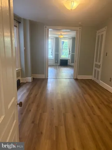 an empty room with wooden floor and a window