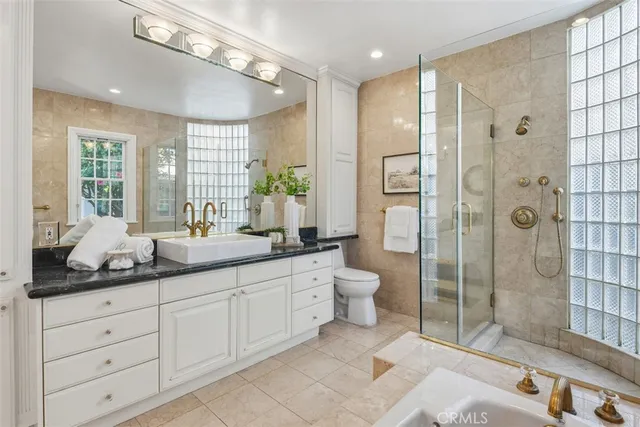 a bathroom with a granite countertop sink mirror and shower