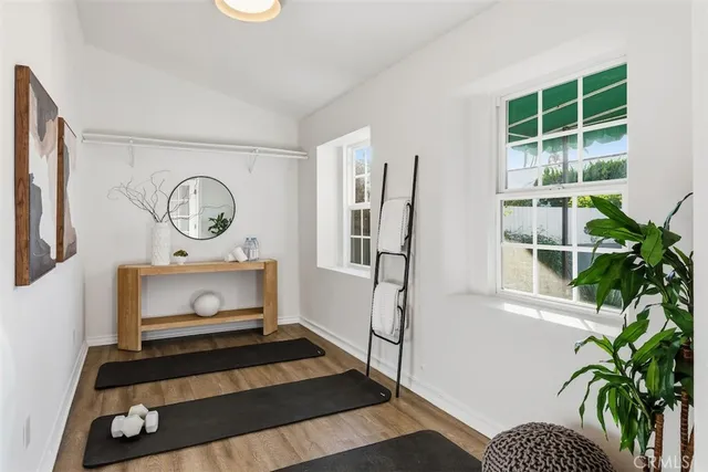 a picture of a room with wooden floor and a potted plant