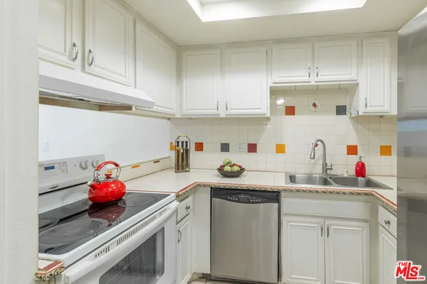 a kitchen with white cabinets and white appliances