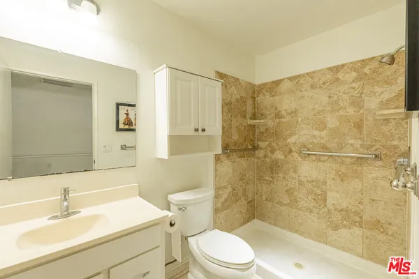 a bathroom with a sink a toilet and shower