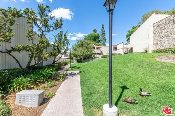 a view of a house with a yard and pathway