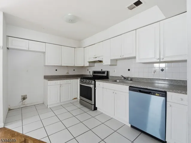 a kitchen with cabinets appliances a sink and a counter top