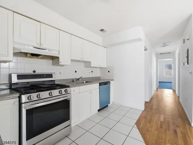 a kitchen with stainless steel appliances granite countertop a stove and a white cabinets