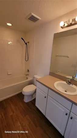 a bathroom with a granite countertop sink a toilet and a mirror