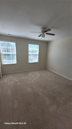an empty room with windows and fan
