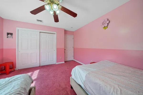 a bedroom with a bed chandelier and a window