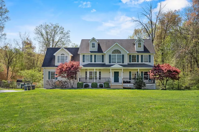 a front view of a house with garden and trees