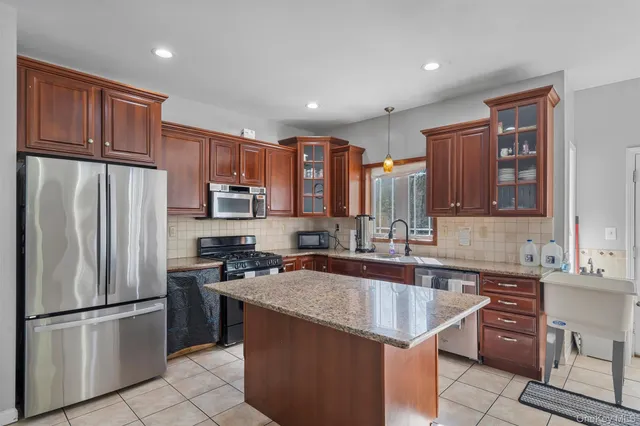 a kitchen with stainless steel appliances granite countertop a refrigerator stove a sink and a microwave