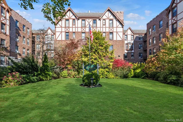 a view of a house next to a big yard and large trees