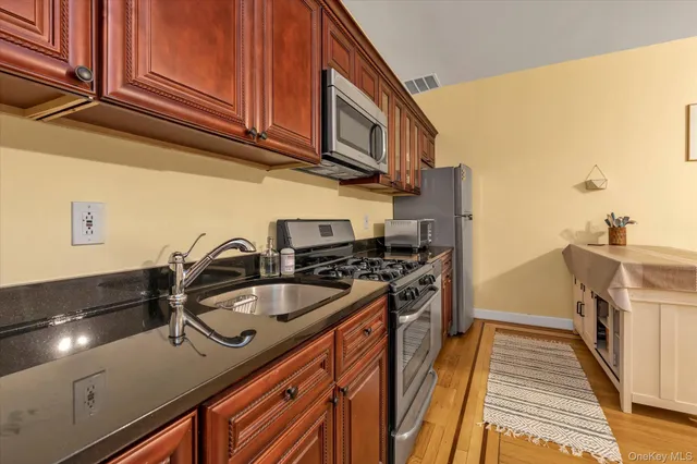 a kitchen with stainless steel appliances granite countertop a sink stove and refrigerator