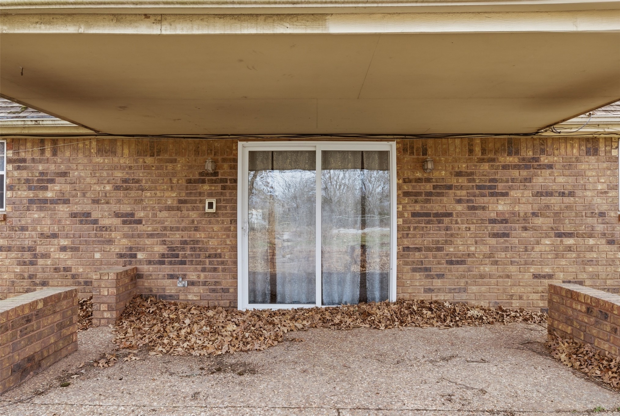 17875 East 589 Road Inola, OK 74036 - Photo 71 of 73 Brick exterior featuring a covered patio with concrete flooring, accented by a sliding glass door