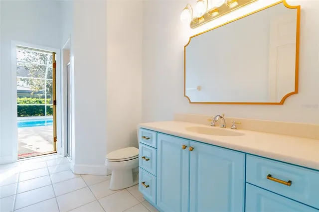 a bathroom with a granite countertop sink a toilet and a mirror